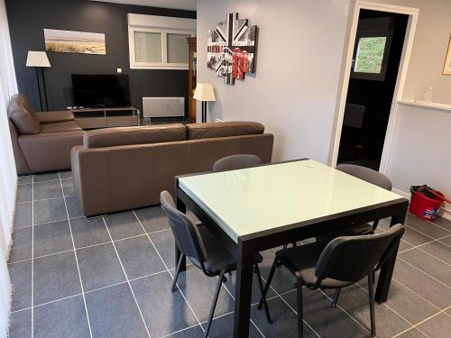 salon ze stołem i kanapą w obiekcie Maison indépendante de vacances HARDELOT PLAGE w mieście Neufchâtel-Hardelot