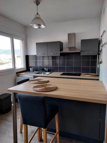 a kitchen with a wooden counter with two chairs at Petit cosy in Clermont-Ferrand