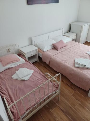 duas camas sentadas uma ao lado da outra num quarto em Apartmany Makarská em Drvenik