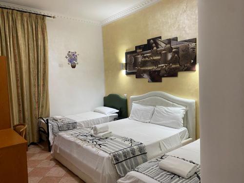 um quarto de hotel com duas camas e um espelho na parede em Aquarium Termini em Roma
