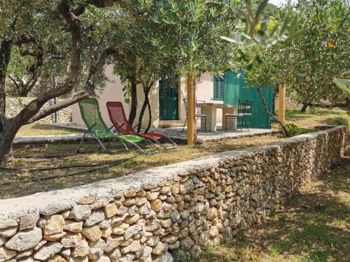 een stenen muur met twee stoelen en een tafel voor een huis bij Holiday home Oliva cottage in Bol