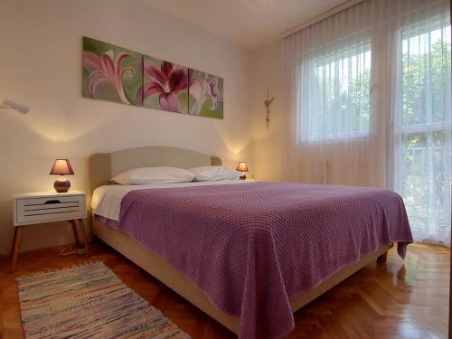 una camera con un grande letto con copriletto viola di Apartment Emili Marina a Marina