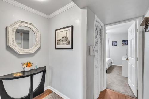 a white hallway with a table and a mirror at Nash Gold Condo, 20min Walk to Downtown, 2Bd,2Bth in Nashville