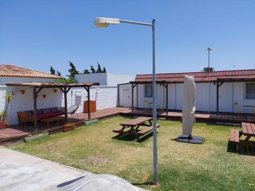 a yard with a picnic table and a street light at Single Fin Conil in Conil de la Frontera