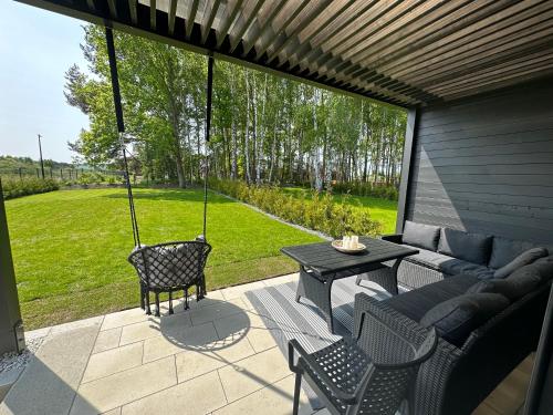 a patio with a couch and a table and chairs at Norda Resort in Dębki
