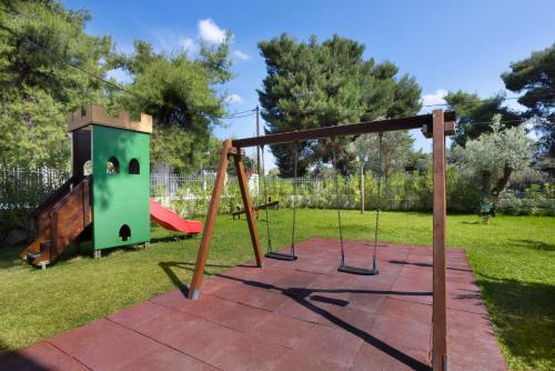 a playground with a swing set in a yard at Negroponte Resort Eretria in Eretria
