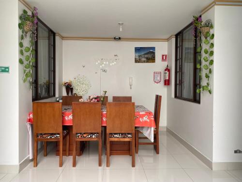 a dining room with a table and chairs at Hostal Arauco in Otavalo