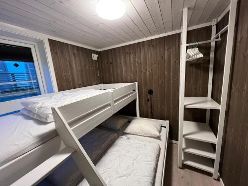 a bedroom with two bunk beds and a ladder at Hytte nær vannet, jacuzzi og sauna in Vradal