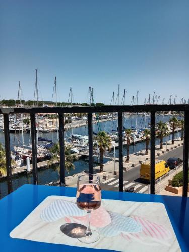 - un verre de vin sur une table avec vue sur le port de plaisance dans l'établissement Gruissan (Aude) Appartement calme, vue sur port de plaisance -Clim, Empl.Parking, à Gruissan