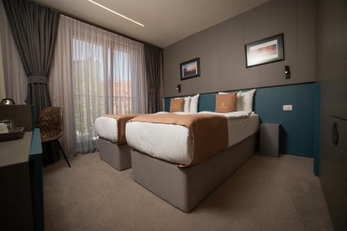 a hotel room with a large bed and a window at Hotel Opera in Pristina
