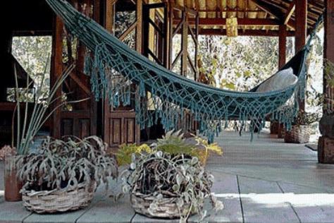 a hammock in a building with potted plants at Residencial Warabi in Visconde De Maua