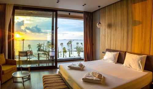a bedroom with a bed with a view of the ocean at Esbjerg Hotel in Vlorë