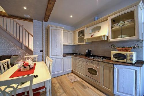 a kitchen with white cabinets and a table with a microwave at Vicolo Mincio Home in Salionze