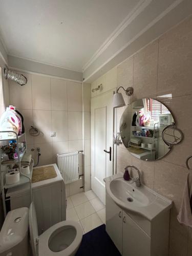 W łazience znajduje się toaleta, umywalka i lustro. w obiekcie Lux Garden Home D w mieście Kumanowo