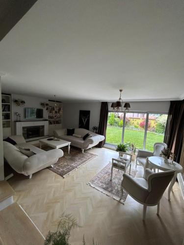 duży salon z białymi meblami i dużym oknem w obiekcie Lux Garden Home D w mieście Kumanowo