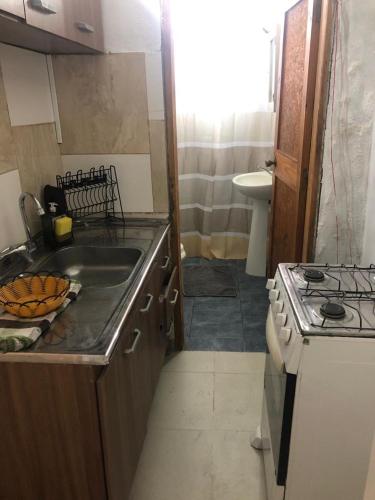 a small kitchen with a stove and a sink at Casita céntrica 1 in Trinidad