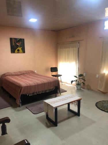 1 dormitorio con cama y banco. en Casita céntrica 1 en Trinidad