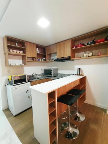 a kitchen with a white counter and a white refrigerator at Hermoso Monoambriente ZV308, Edificio Zetta Village Airport in Asunción