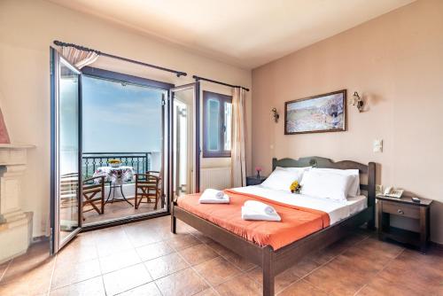 a bedroom with a bed and a balcony at Hotel Marina in Anogia
