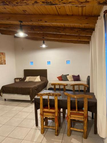 een slaapkamer met 2 bedden en 2 stoelen bij Departamento con parque in San Martín de los Andes