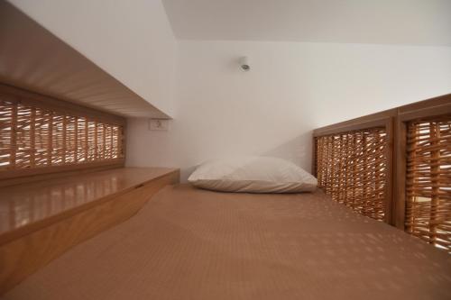 a bedroom with a bed and two windows at Lipsi Sands in Leipsoi