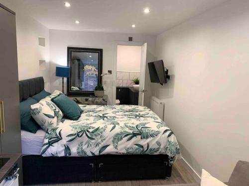 um quarto com uma cama e um espelho em Private entrance 1 bed studio near Salford Royal em Manchester