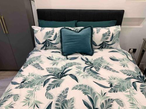 1 cama con edredón blanco y negro y almohada azul en Private entrance 1 bed studio near Salford Royal, en Mánchester