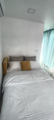 a large white bed in a room with a window at Tiny Village Mamaia Nord - House 1 in Mamaia Sat/Năvodari