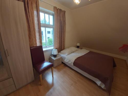 a bedroom with a bed and a chair and a window at Viva Apartment in Tallinn