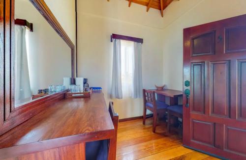 a room with a wooden table and a wooden door at Sandy Feet Beach Resort in Placencia Village