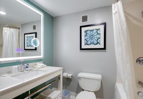 bagno con servizi igienici, lavandino e specchio di Four Points by Sheraton York a York