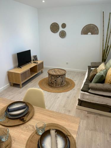ein Wohnzimmer mit einem Sofa und einem Tisch in der Unterkunft Pisos viajer@s in O Grove
