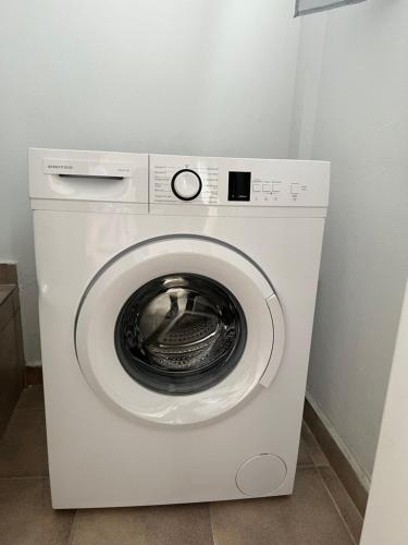a white washing machine sitting in a room at Melinda’s cozy apartments in Plomarion