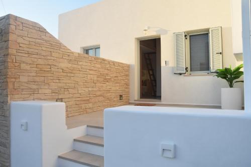 a facade of a house with a brick wall at Lipsi Sands in Lipsoi