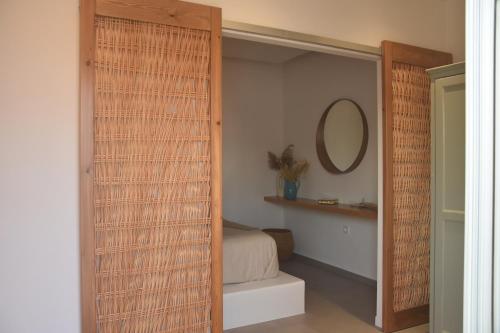 um quarto com um armário com uma cama e um espelho em Lipsi Sands em Leipsoi