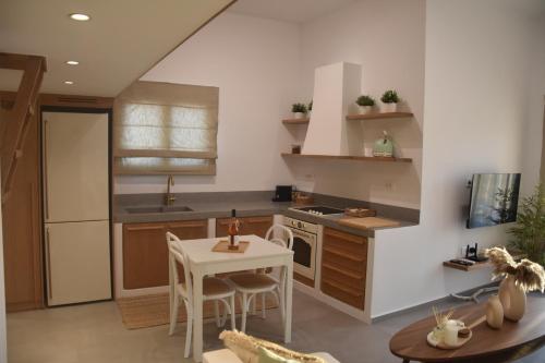 a kitchen with a table and a stove and a sink at Lipsi Sands in Lipsoi