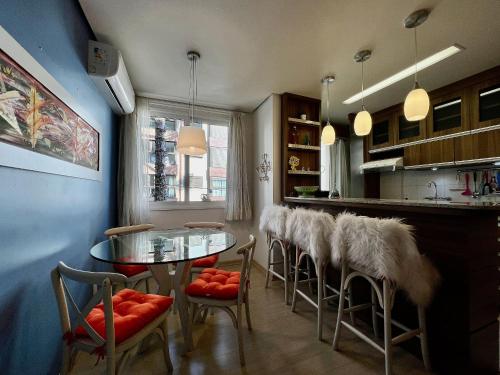 cocina con mesa de cristal y taburetes en Apartamento Príncipe Villevert 1 dorm by Achei, en Canela
