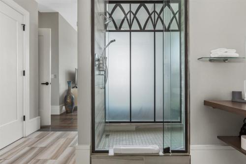 La salle de bains est pourvue d'une douche avec une porte en verre. dans l'établissement 'Arras Altitude Adjustment' A Luxury Downtown Condo with Mountain and City Views at Arras Vacation Rentals, à Asheville