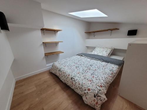 a small bedroom with a bed and shelves at 3D- Studio tout équipé avec cuisine 10 mins de Paris in Issy-les-Moulineaux