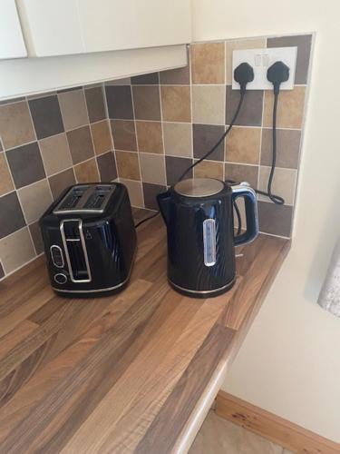 a toaster and coffee maker sitting on a counter in a kitchen at JMD Lodge - Self Catering Property in the heart of The Burren between Ballyvaughan, Lisdoonvarna, Doolin and Kilfenora in County Clare Ireland in Ballyvaughan