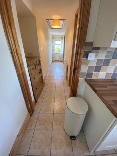 a hallway of a kitchen with a trash can at JMD Lodge - Self Catering Property in the heart of The Burren between Ballyvaughan, Lisdoonvarna, Doolin and Kilfenora in County Clare Ireland in Ballyvaughan