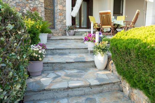 a set of stairs leading to a patio with flowers at Mirovili House in Káto Lekhónia