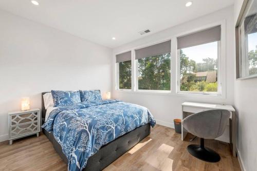 a bedroom with a bed and a desk and windows at Fabulous Beach Get Away - Brand New Beach House in Half Moon Bay