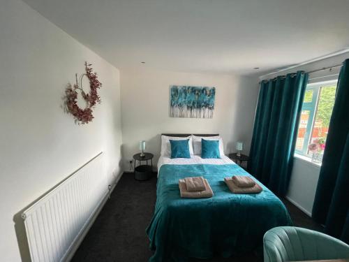 a bedroom with a bed with two towels on it at Large Stylish 2 Bedroom Apartment Stevenage Sleep 6 in Stevenage