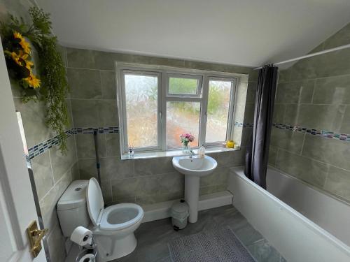 a bathroom with a toilet and a sink and a tub at Large Stylish 2 Bedroom Apartment Stevenage Sleep 6 in Stevenage