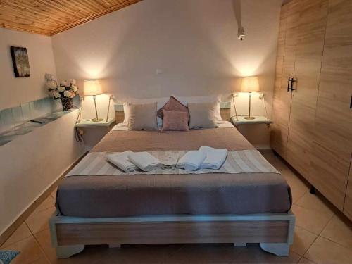 a bedroom with a large bed with two lamps at SUNNY STUDIO in Skala Marion