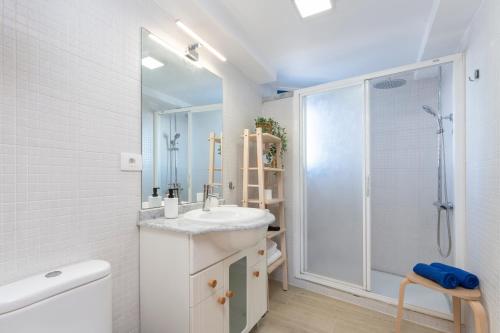 La salle de bains blanche est pourvue d'un lavabo et d'une douche. dans l'établissement Agaete White&Blue Rooftop, à Agaete