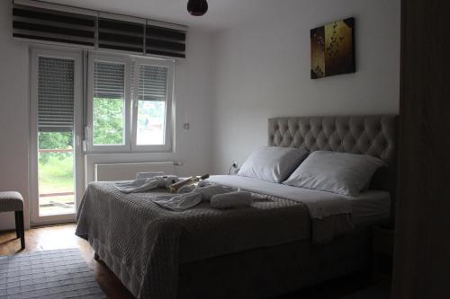 a bedroom with a bed with towels on it at Apartmani Ramonda in Teslić