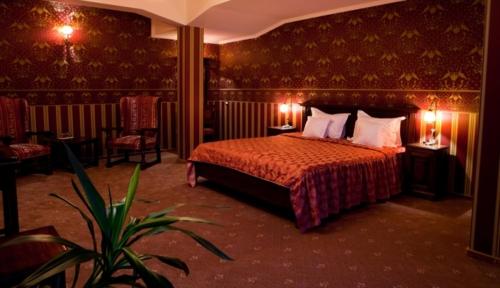 a bedroom with a bed with two lamps and a plant at Hotel Majestic in Iaşi