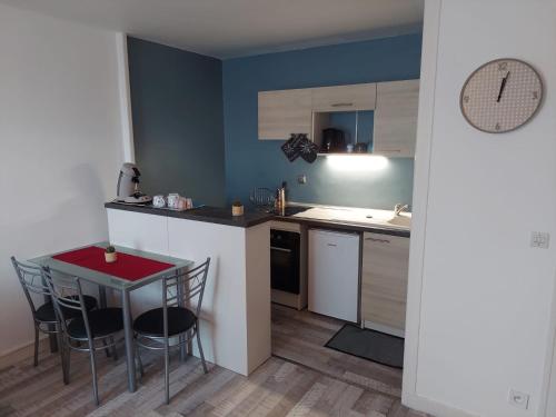 a small kitchen with a small table and chairs at Appartement équipé proche aéroport et gare in Beauvais